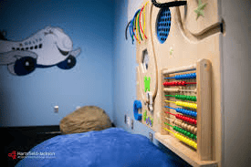 The images show the sensory room at Hartsfield-Jackson Atlanta International Airport. With sky-blue walls and some sensory tools, it provides engagement for the neurodivergent population, especially kids.